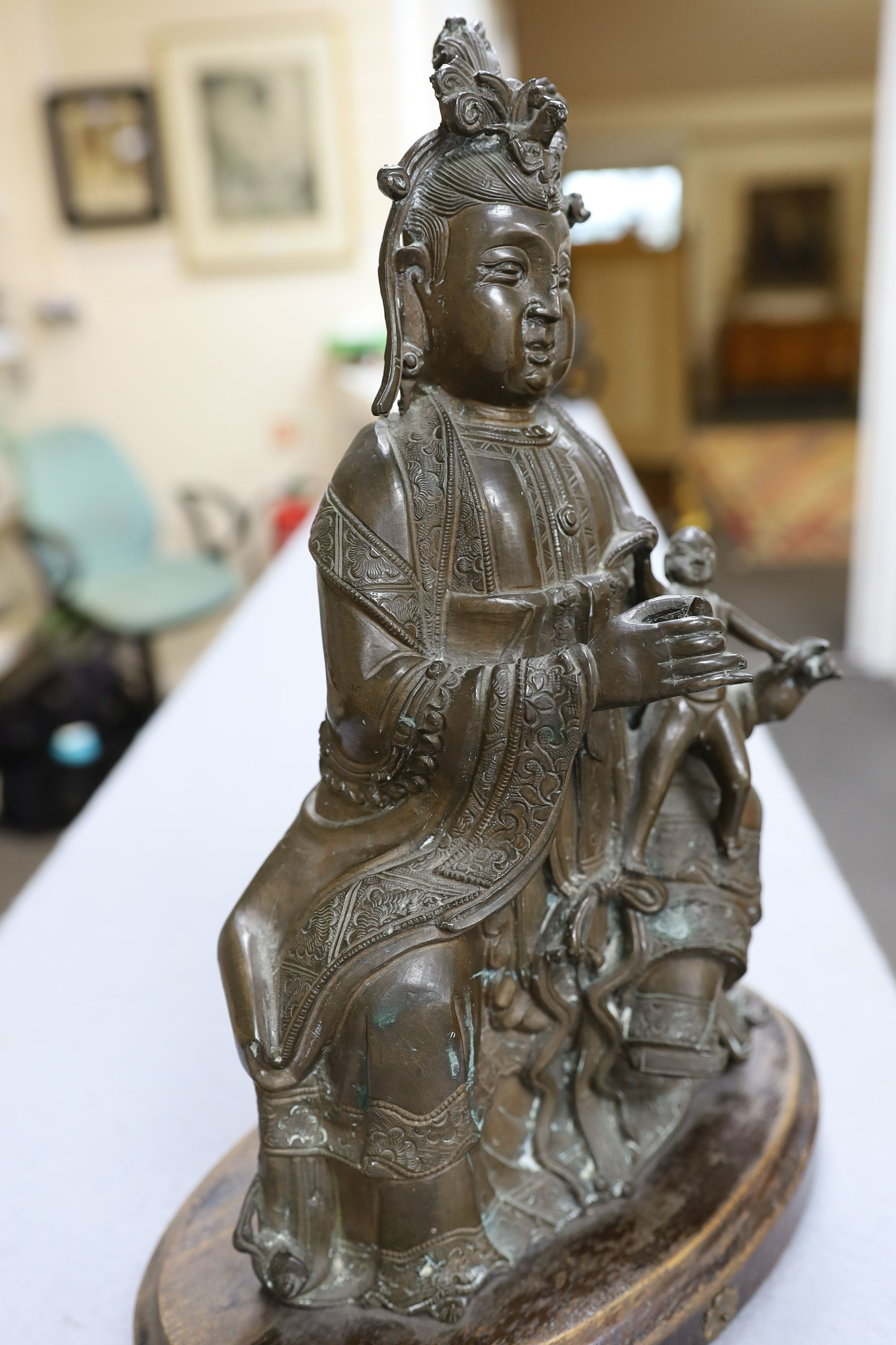 A large Chinese bronze group of Xi Wangmu and a child, late Ming dynasty, 31.5cm high excluding later wood stand